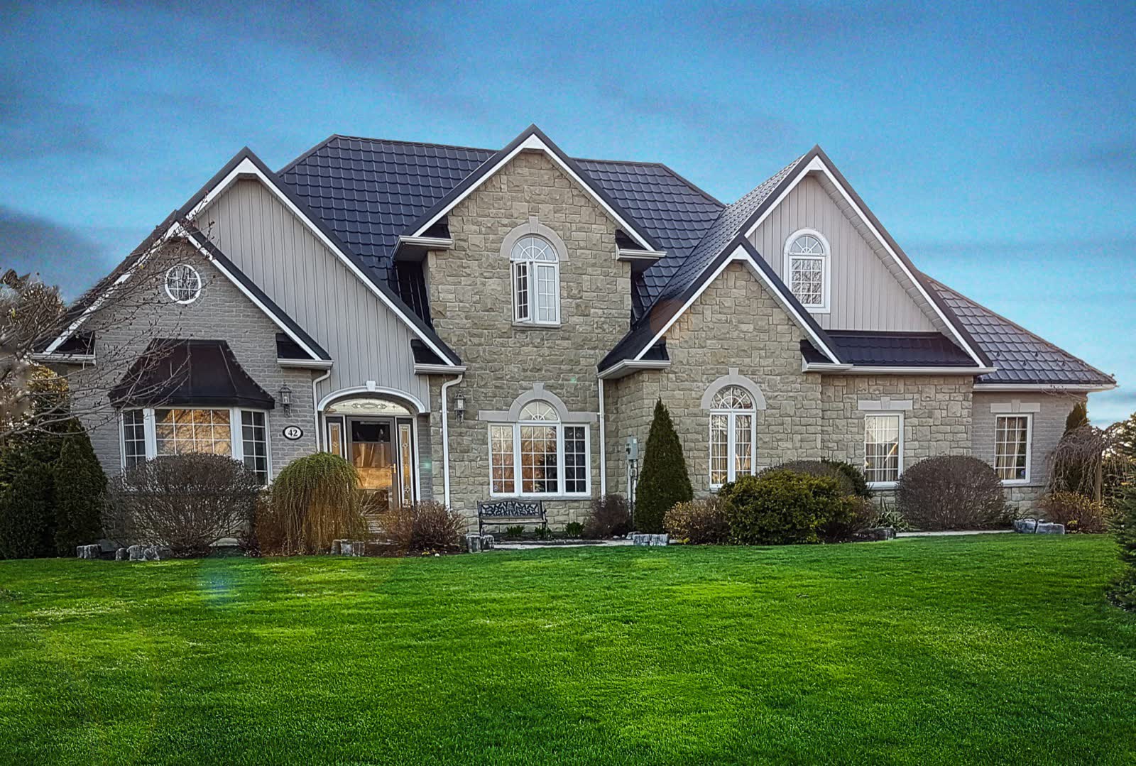 Stone home with a charcoal steel roof