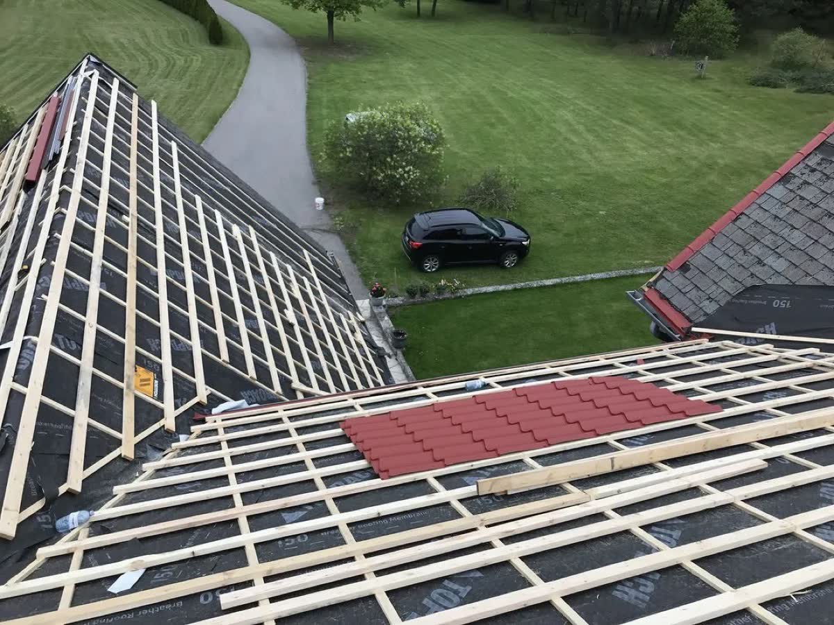 Steel tiles being installed over horizontal strapping